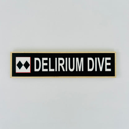 Rectangular sign with 'DELIRIUM DIVE' text on a light gray background