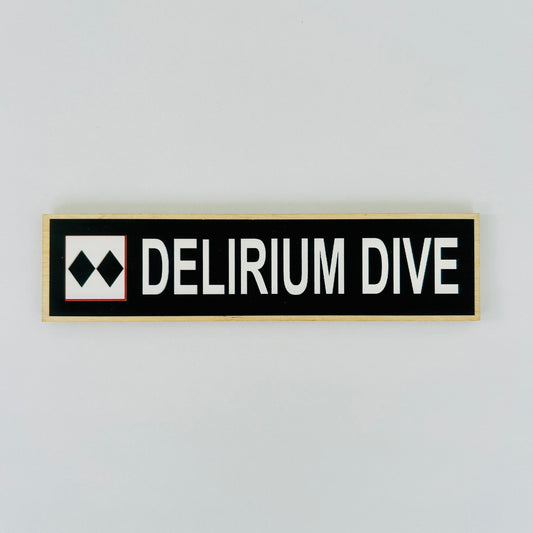 Rectangular sign with 'DELIRIUM DIVE' text on a light gray background