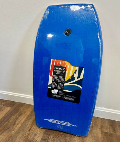 Blue bodyboard with Hurley logo on a white wall background