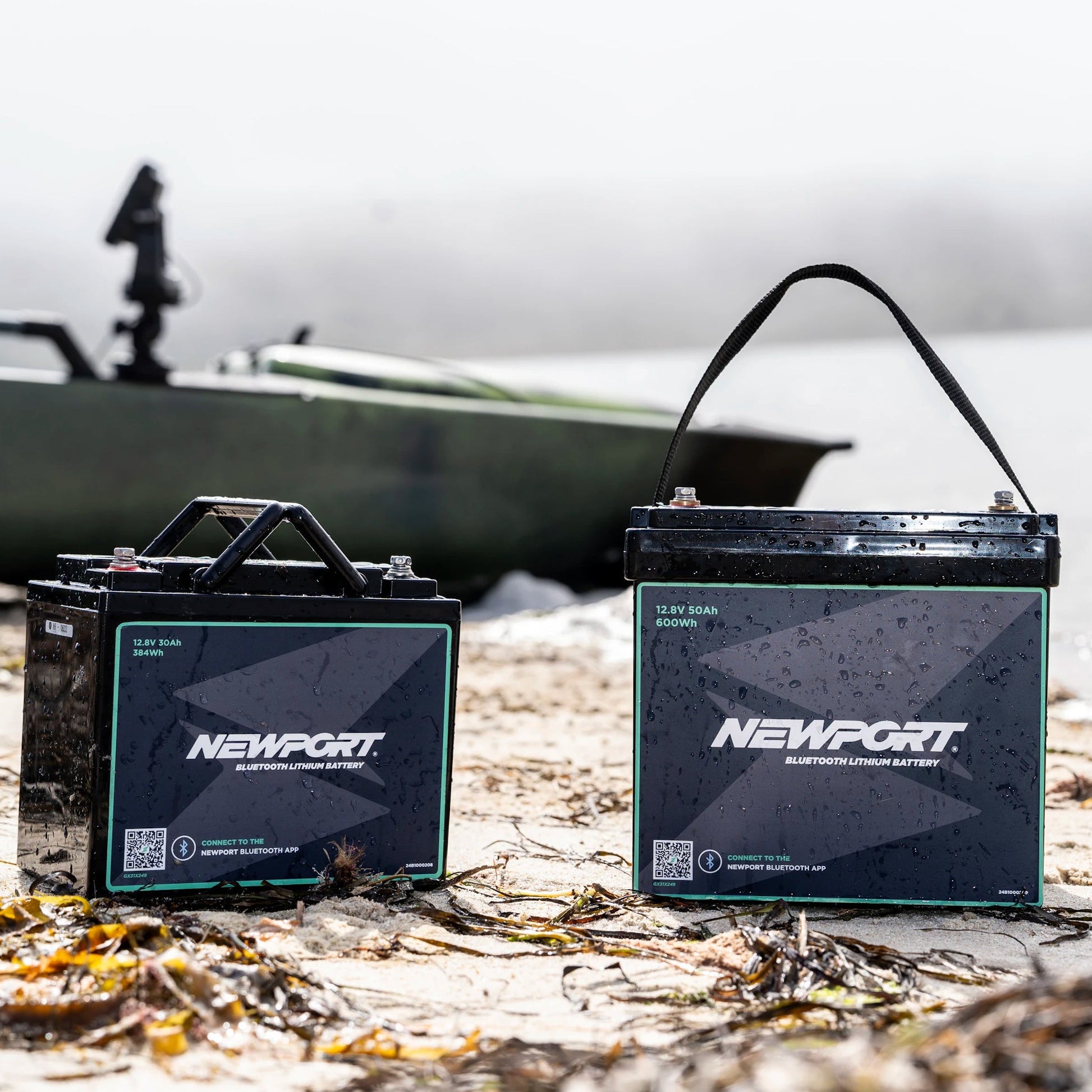Two Newport batteries on a beach with a boat in the background