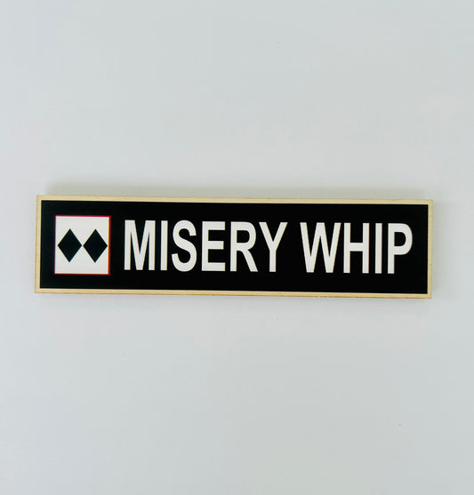 Rectangular sign with 'MISERY WHIP' text on a white background