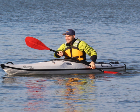 Person kayaking on a calm body of water