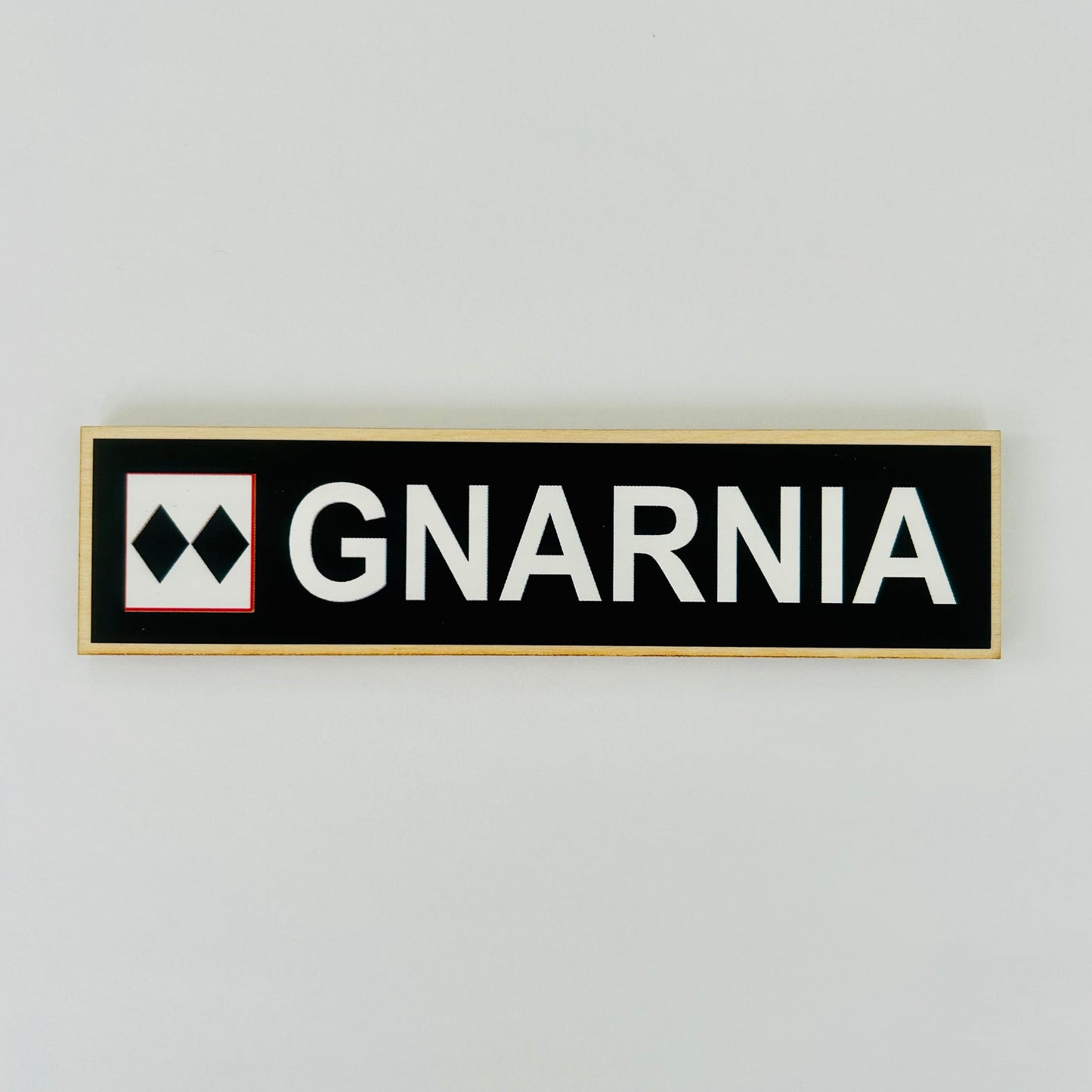 GNARNIA logo on a black rectangular sign with white text against a light gray background