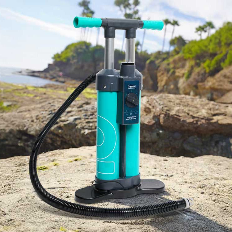 Turquoise hand pump on a rocky surface with a scenic background