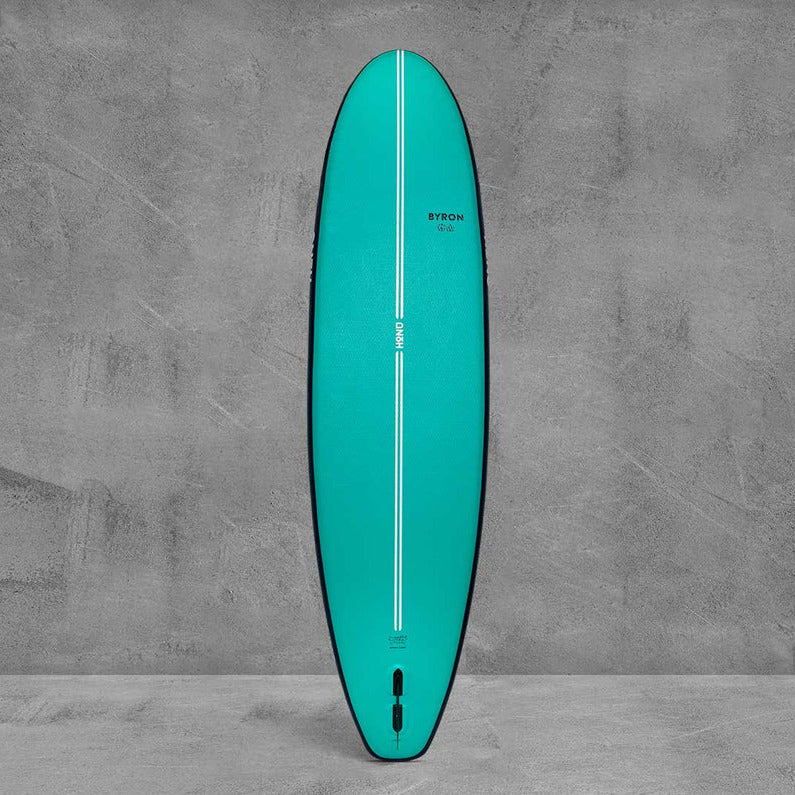 Teal surfboard with black edges on a gray concrete background