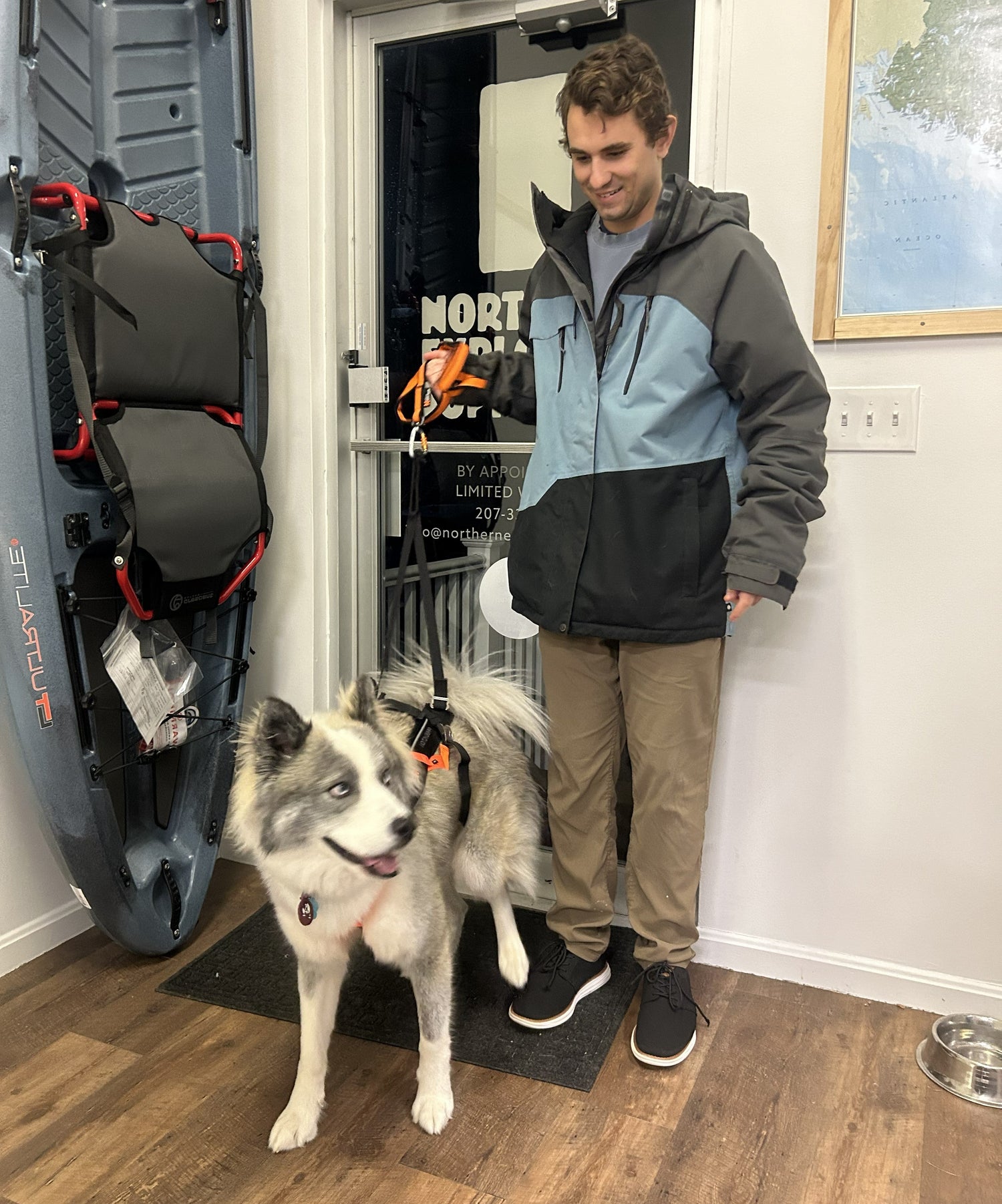 Nonstop Freemotion Dog Harness on Husky with Man at Entrance to Northern Explorer Supply in York, Maine